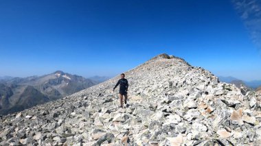 Genç adam dağlarda yürüyüş yapıyor.