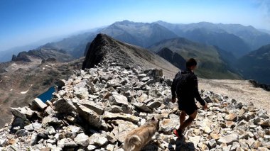 Genç adam dağlarda yürüyüş yapıyor.