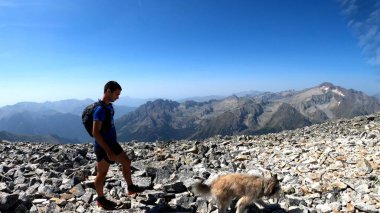Genç adam dağlarda yürüyüş yapıyor.