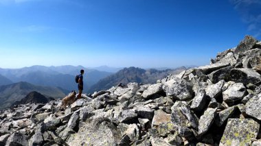 Genç adam dağlarda yürüyüş yapıyor.