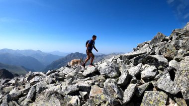 Genç adam dağlarda yürüyüş yapıyor.