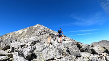 Genç adam dağlarda yürüyüş yapıyor.