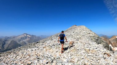 Genç adam dağlarda yürüyüş yapıyor.