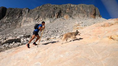 Genç adam dağlarda yürüyüş yapıyor.