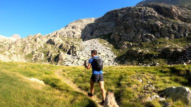 Genç adam dağlarda yürüyüş yapıyor.