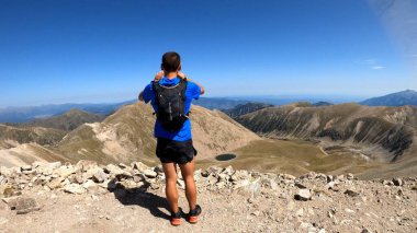 Genç adam dağlarda yürüyüş yapıyor.