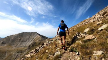 Genç adam dağlarda yürüyüş yapıyor.