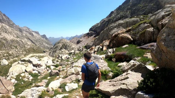 Genç adam dağlarda yürüyüş yapıyor.