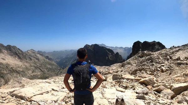 Genç adam dağlarda yürüyüş yapıyor.