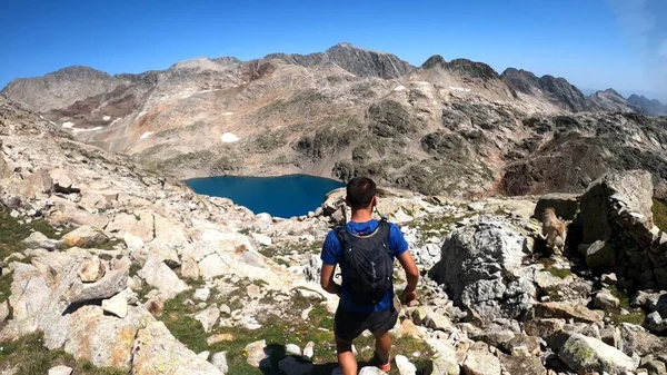 Genç adam dağlarda yürüyüş yapıyor.