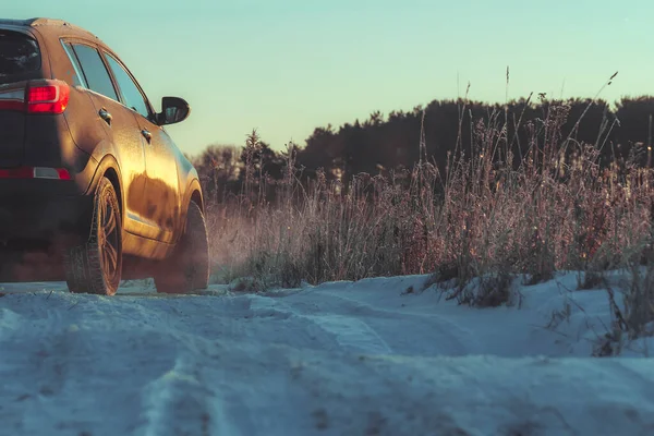 Bil med vinterdäck och däckspår på vintern grov väg i vintersäsongen Royaltyfria Stockfoton