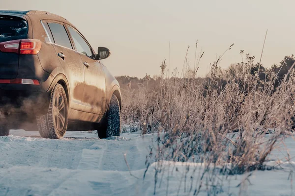 SUV bil kör på snöig väg på landsbygden på vintern. Farligt istäcke Royaltyfria Stockbilder