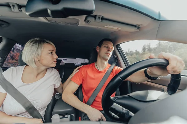 A feleség fáradt férjként ébred, elalszik a volánnál. Veszélyes alvás vezetés közben. Közúti baleset, a járművezető elájulása — Stock Fotó