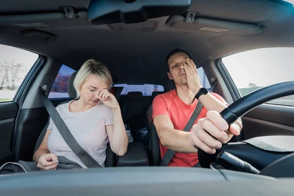 Álmos, fáradt férfi és nő gyorsan elalszanak, miközben autót vezetnek. Ásítás arról, hogy a sofőr tengeri övet visel a dugóban. Közúton nem biztonságos — Stock Fotó