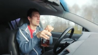 İçkili sarhoş bir adam arabayla yolda araba kullanıyor.