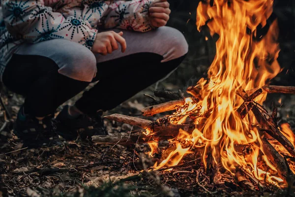 Tonårstjej tänder stor eld i skogen. Fara för löpeld. Miljöskydd. Farlig eldslåga i naturen Stockbild