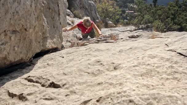Adolescente escalador escalada escalada pared de piedra en las montañas al aire libre en verano día soleado — Vídeo de stock