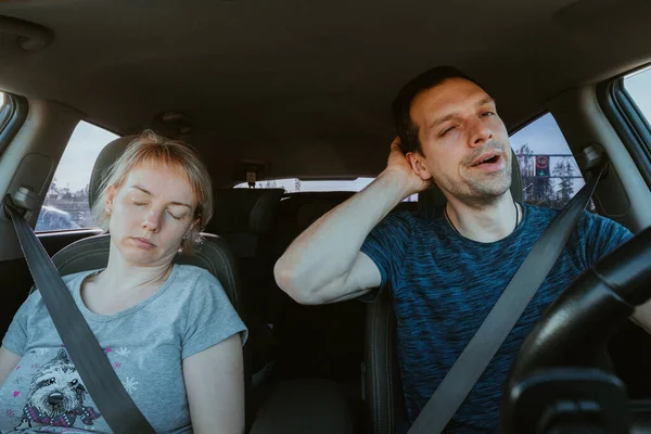 Grane hatás. Fáradt ásító férfi vezetés egy autó és alvó nő együtt utazás közben — Stock Fotó