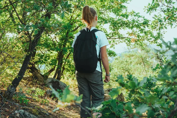 Viaggiatore ragazza con zaino a piedi sul sentiero nella foresta. Viaggio avventura natura. Viaggio di vacanza estiva. Turismo escursionistico — Foto Stock