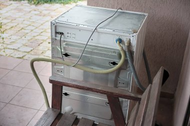 Kırsal bir evin terasındaki bozuk çamaşır makinesi.