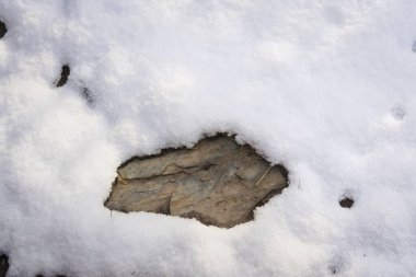 Karların altından çıkan taş.