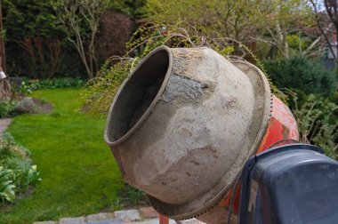 Kırsal bir evin arka bahçesinde eski bir beton karıştırıcı. 