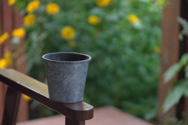 Metal, boş tencere arka planda bir sandalyede duruyor. 