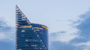 Riga, Letonya: 24 Eylül 2020: Swedbank cam mimarisi bina ışıkları akşam karanlığında yanmaya başladı. Bulutları gece gündüz hareket ettiriyor