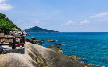 Koh Tao Körfezi 'nden küçük yeşil ada manzarası, kristal mavi su, büyük kayalar.