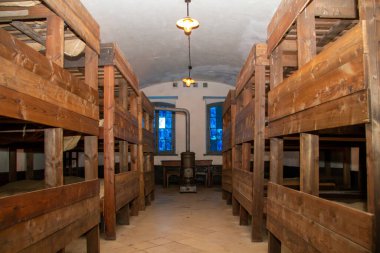 Belgium, Puurs, April 16, 2021. Fort Breendonk was a concentration camp during WWII. Bedroom with bunk beds and old stove