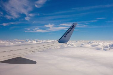 Gökyüzünde, Belçika, 7 Temmuz 2021. Bulutların üstünde bir Ryanair uçağının kanadı