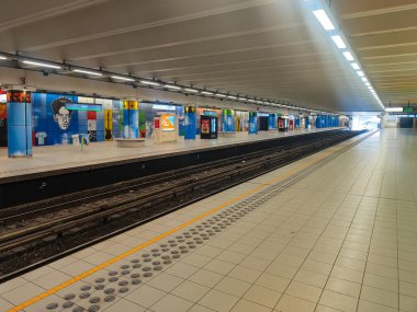 7 Ocak 2026. Brüksel Heysel metro istasyonu, Heizel, yolcuları olmadan, mavi ve renkli panellerle süslenmiş uzun bir platform ve duvarlarla.