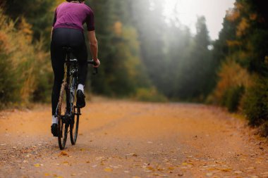 Düşen yapraklar üzerinde profesyonel bir yol bisikletçisinin seçici odak noktası. Bir sonbahar sabahı ForestHigh kalitesinde bir fotoğraf.