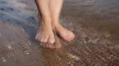 Güneşli kumsalda yürüyen kadın