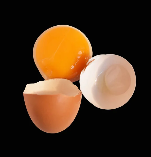 本当の鶏の卵 茶色の半分の壊れた卵 クリッピングパスを持つ卵の黄身 黒の背景に影はありません — ストック写真