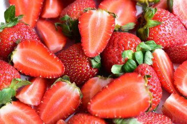 Beyaz tabak arka planında izole edilmiş çilekler, taze dilimler, parçalar, yarım çilek meyvesi.