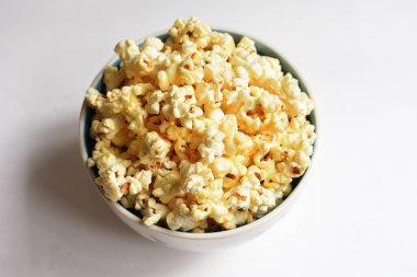 Beyaz arka planda izole edilmiş patlamış mısır kasesi, tatlı tereyağı veya karamelli patlamış mısır, tuzlu