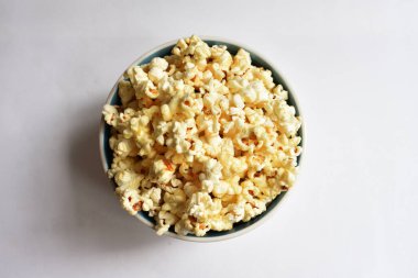 Beyaz arka planda izole edilmiş patlamış mısır kasesi, tatlı tereyağı veya karamelli patlamış mısır, tuzlu