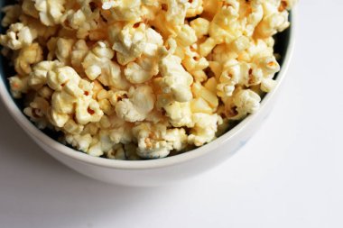 Beyaz arka planda izole edilmiş patlamış mısır kasesi, tatlı tereyağı veya karamelli patlamış mısır, tuzlu