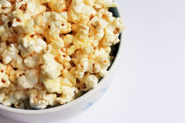 Beyaz arka planda izole edilmiş patlamış mısır kasesi, tatlı tereyağı veya karamelli patlamış mısır, tuzlu