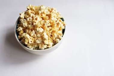 Beyaz arka planda izole edilmiş patlamış mısır kasesi, tatlı tereyağı veya karamelli patlamış mısır, tuzlu