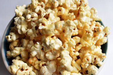 Beyaz arka planda izole edilmiş patlamış mısır kasesi, tatlı tereyağı veya karamelli patlamış mısır, tuzlu