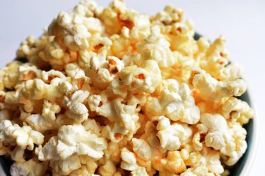 Beyaz arka planda izole edilmiş patlamış mısır kasesi, tatlı tereyağı veya karamelli patlamış mısır, tuzlu