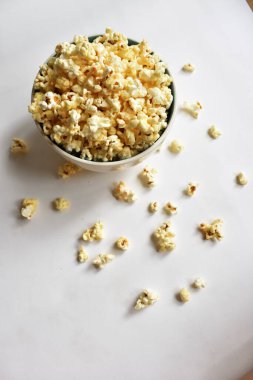 Beyaz arka planda izole edilmiş patlamış mısır kasesi, tatlı tereyağı veya karamelli patlamış mısır, tuzlu