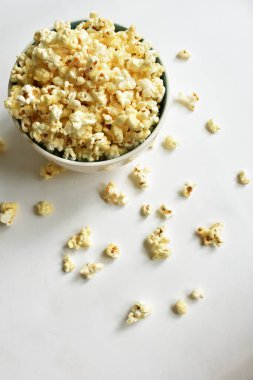 Beyaz arka planda izole edilmiş patlamış mısır kasesi, tatlı tereyağı veya karamelli patlamış mısır, tuzlu