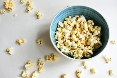 Beyaz arka planda izole edilmiş patlamış mısır kasesi, tatlı tereyağı veya karamelli patlamış mısır, tuzlu