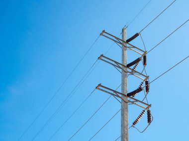 Arka planda yüksek voltaj direği parlak mavi bir gökyüzü..