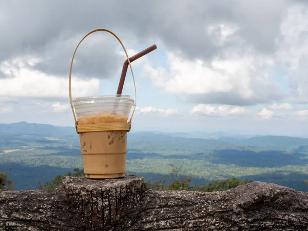 A glass of Thai tea on a mountain background in Khao Yai National Park