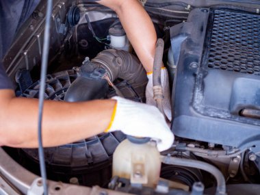 Tamirci araba tamir ederken ingiliz anahtarı tutuyor..