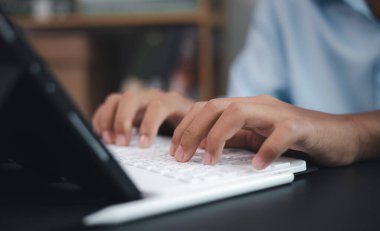 İşletme ve eğitim için çevrimiçi öğrenme, uzaktan çalışma, dijital iletişim ve modern teknoloji yaşam tarzını temsil eden bir klavyeye yazı yazan ellerin yakın çekimi.